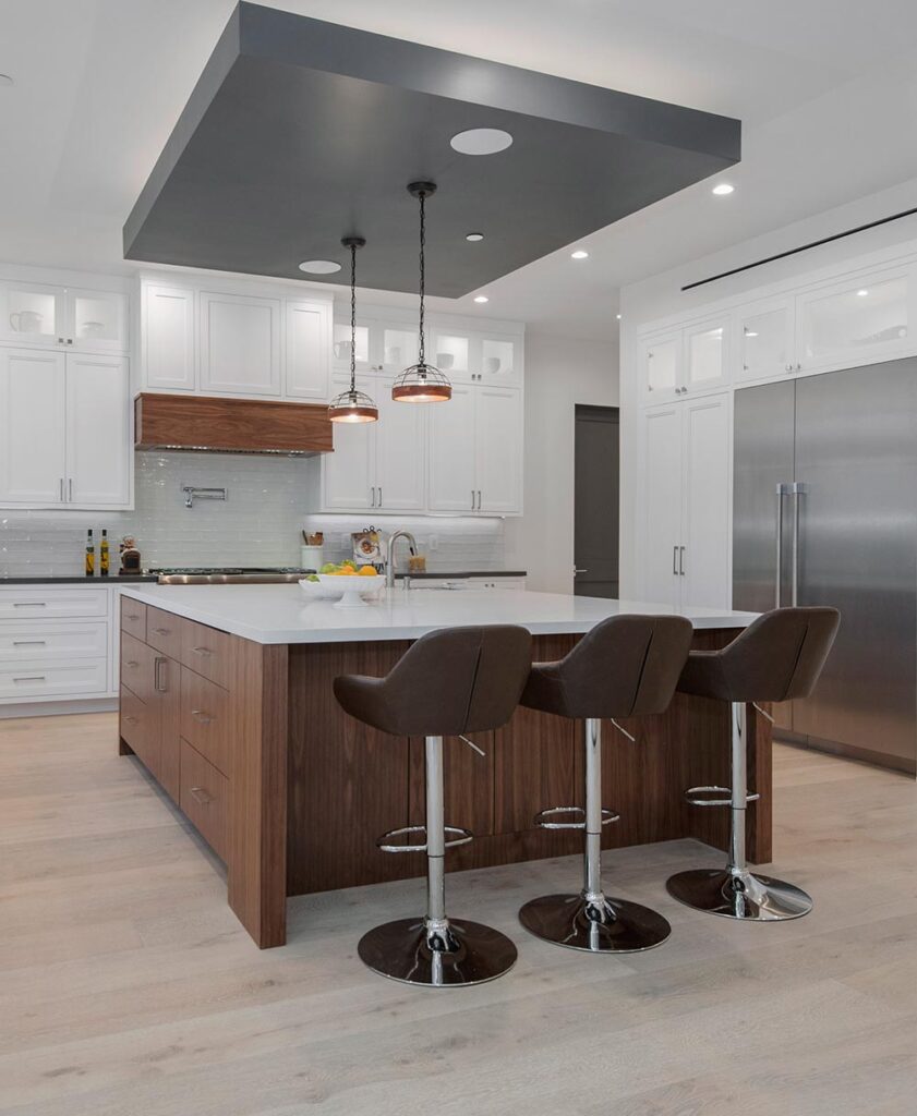 Luxury kitchen and home remodeling in Brighton MI featuring a marble waterfall island and custom lighting.